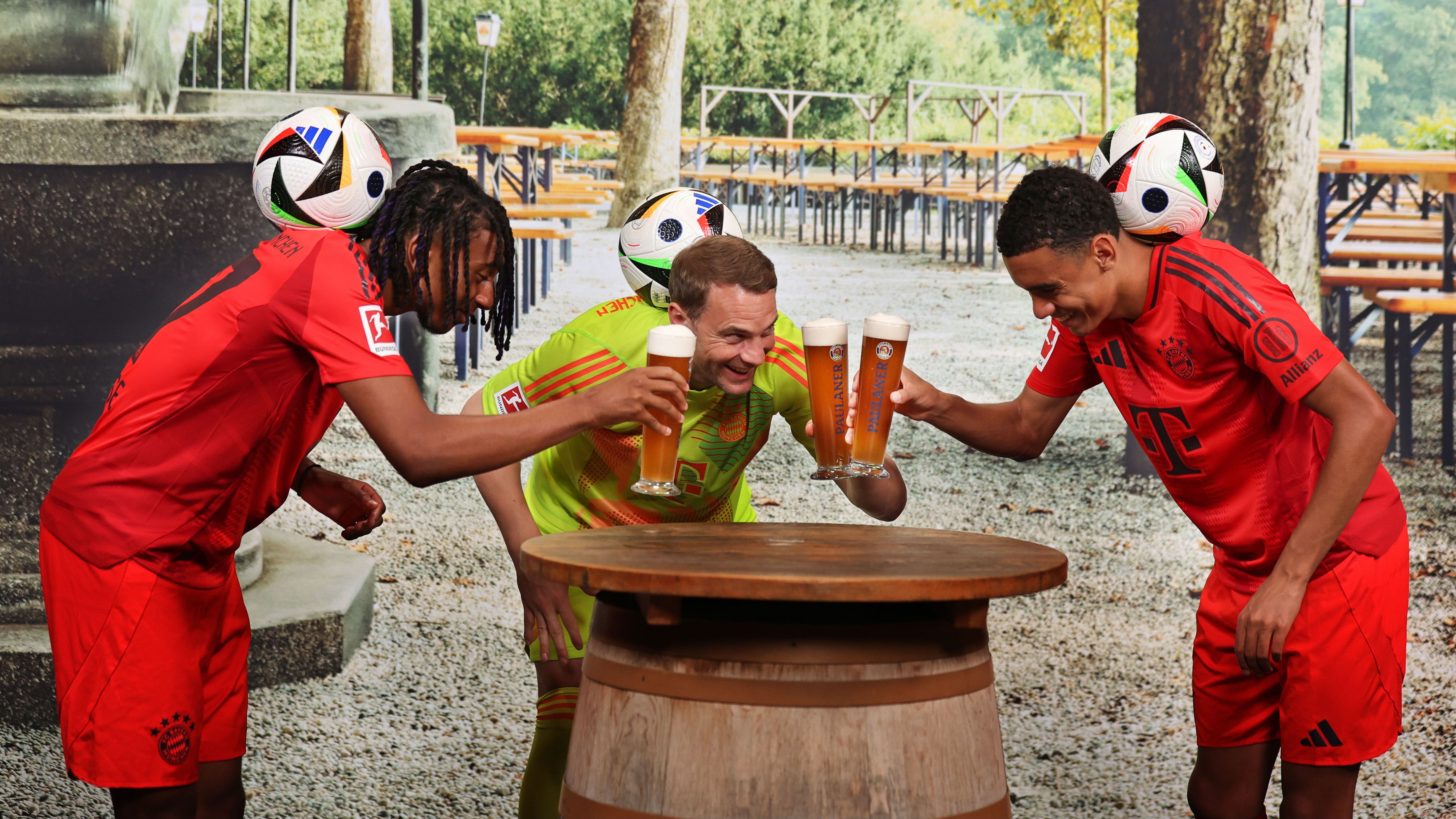 <strong>Bayern München beim Lederhosen-Shooting</strong><br>Neuzugang Michael Olise führt mit Manuel Neuer und Jamal Musiala eine beeindruckende Jonglier-Einlage vor.