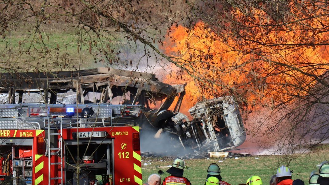 Eine Stadtbahn und ein Tanklaster stehen nach einer Kollision in Flammen.