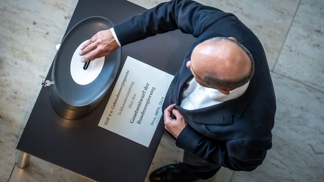 Bundeskanzler Olaf Scholz (SPD), wirft seine Stimmkarte zum Gebäudeenergiegesetzes im Bundestag ein. 