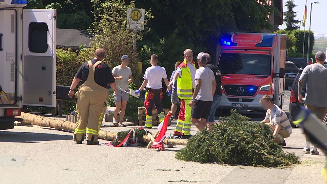 Ein Maibaum ist auf eine Menschenmenge gestürzt.