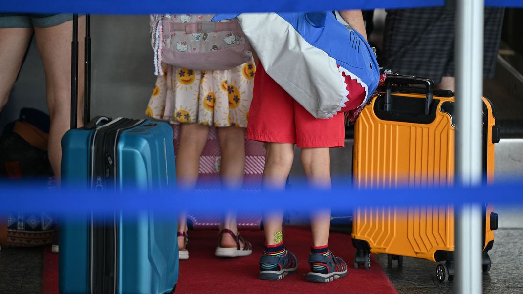 4. Juli 2025, Hessen, Frankfurt/Main: Eine Familie steht am Frankfurter Flughafen an einem Check-In-Schalter der Lufthansa. 