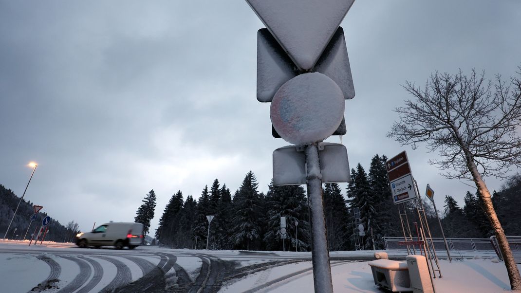 Verkehrsschilder sind am frühen Morgen im Ortsteil Oberjoch mit Schnee bedeckt.