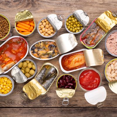 Canned food on wooden background, top view