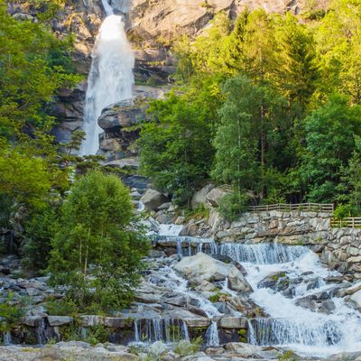 The particular waterfall of Noasca in Piedmont/ Italy is located behind the houses on the border of the famous Great Paradise National Park