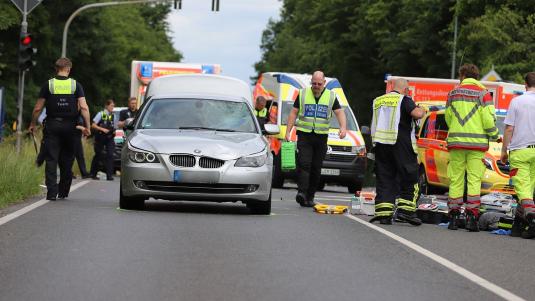 Einsatzkräfte der Polizei, der Feuerwehr und vom Rettungsdienst sind nach dem Unfall in Hürth neben dem Unfallfahrzeug im Einsatz.