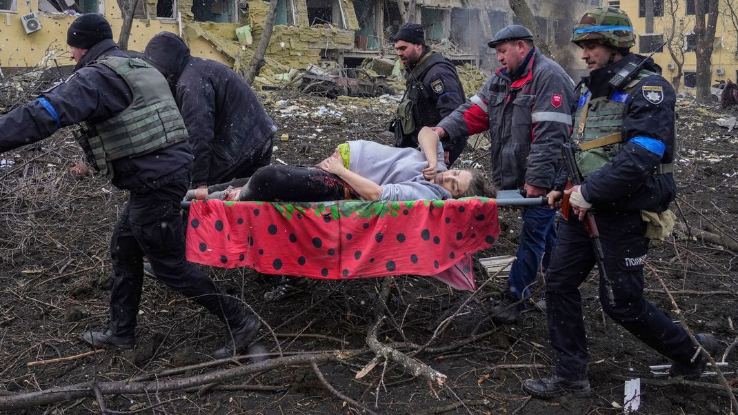 Eine schwangere Frau, die nach einem russischen Militärschlag in Mariupol durch die Trümmer einer Entbindungsklinik getragen wird.