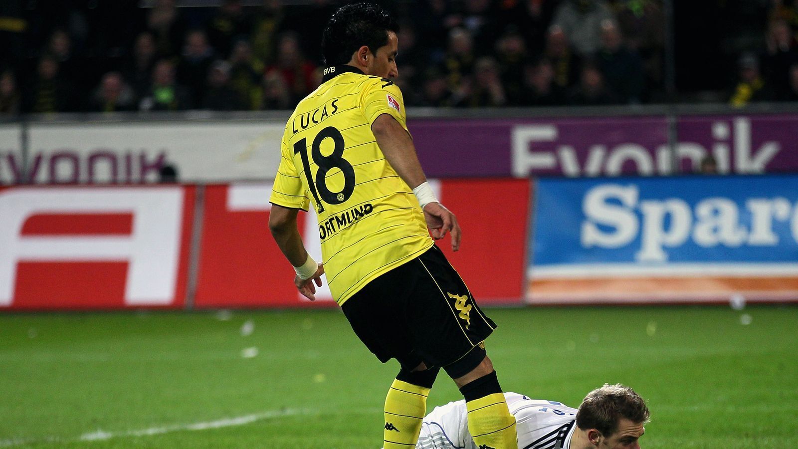 
                <strong>Lucas Barrios</strong><br>
                Als Lucas Barrios im Sommer 2009 zur Borussia wechselte, war der Stürmer mit damals 24 Jahren schon ein großer Name und zu diesem Zeitpunkt auch noch Welttorjäger. Der Südamerikaner, der einen paraguayischen und einen argentinischen Pass besitzt, schnappte sich als Neuzugang die Nummer 18 beim BVB, die zu diesem Zeitpunkt schon zwei Jahre nicht vergeben war. Gleich von Beginn an überzeugte Barrios, erzielte in seiner ersten BVB-Saison 19 Treffer und hatte mit 16 Bundesliga-Toren auch großen Anteil am Meistertitel 2010/11. In der Saison 2011/12 sank dann der Stern von Barrios beim BVB etwas, weil Robert Lewandowski aus seinem Schatten hervortrat. Im Sommer 2012 verabschiedete sich Barrios in Richtung China. Heute spielt der 35-Jährige in Argentinien für Club de Gimnasia y Esgrima La Plata unter keinem Geringeren als Trainer Diego Maradona.
              