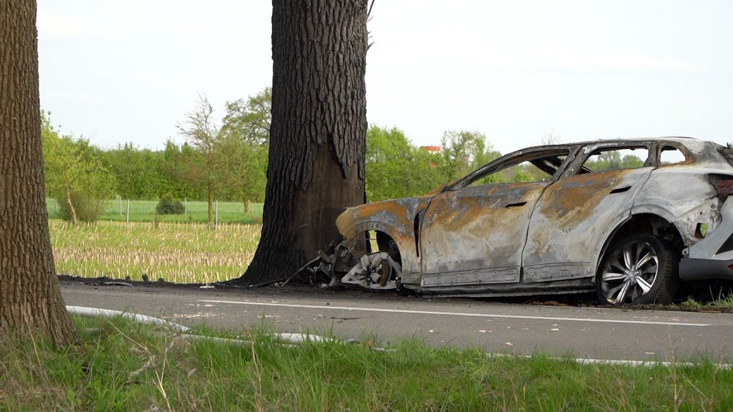 Ein verunfalltes und ausgebranntes Auto liegt im Kreis Osnabrück an der Unfallstelle. 