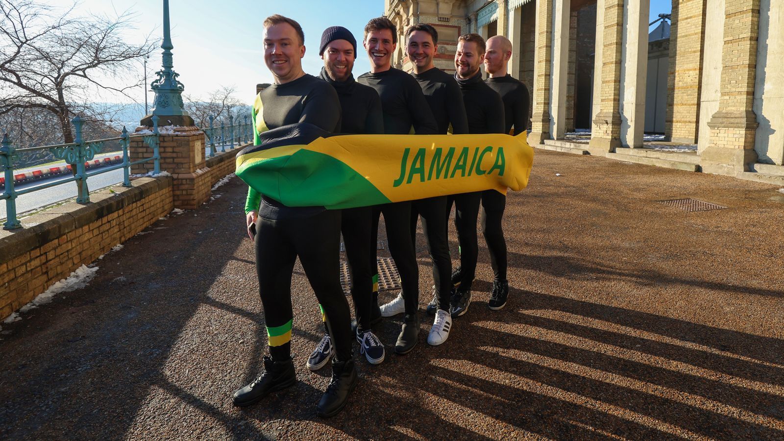 
                <strong>Cool Runnings: Vom Eiskanal in die Darts-Halle</strong><br>
                Sie sind die Männer mit einem harten Job und fahren mit dem Bob. Scheinbar auch ohne Eiskanal, um möglichst schnell zum Ally Pally zu gelangen. Die jamaikanischen Jungs von "Cool Runnings" sind vermutlich Stolz auf eine solche Leistung ihrer Fans und womöglich ein wenig neidisch darauf, nicht selbst bei der Darts WM zu Gast zu sein.
              