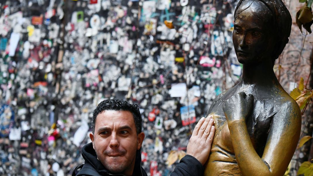 Ein Tourist berührt in Verona die Brust der Statue Julias - wegen dieser Tradition hat die Bronzefigur nun ein Loch.