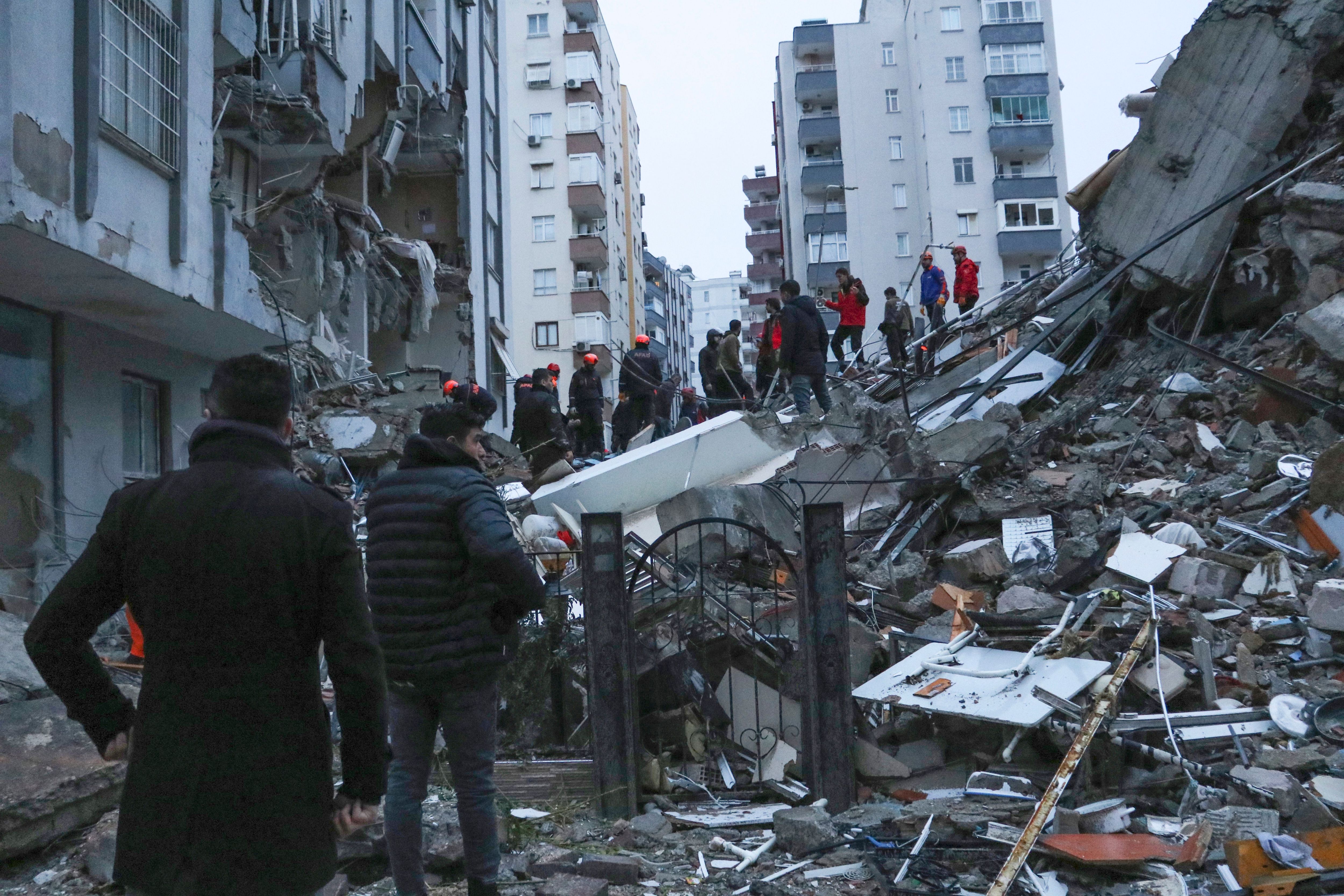 Menschen und Rettungsteams in Adana versuchen, eingeschlossene Bewohner in eingestürzten Gebäuden zu erreichen.