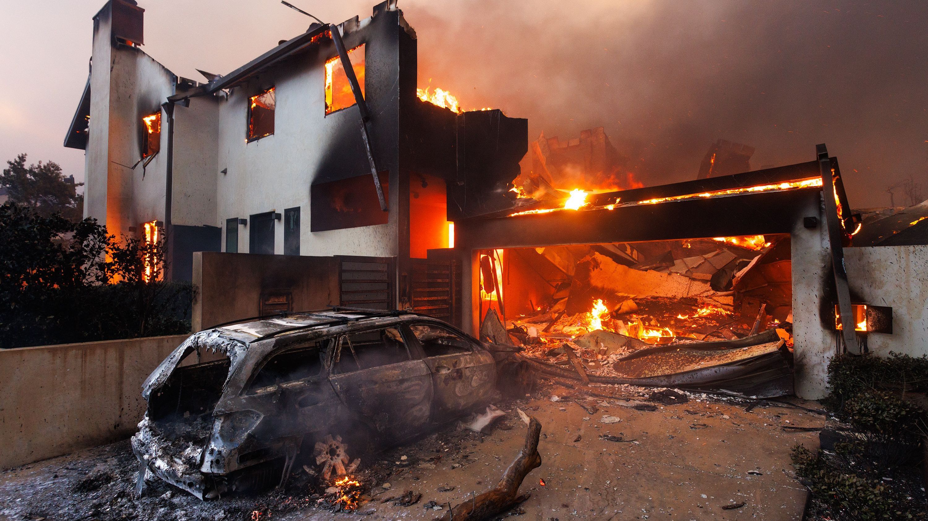 Los Angeles: Ein verbranntes Auto vor einem abgebrannten Haus in Pacific Palisades während des zweiten Tages des Palisades-Feuers.