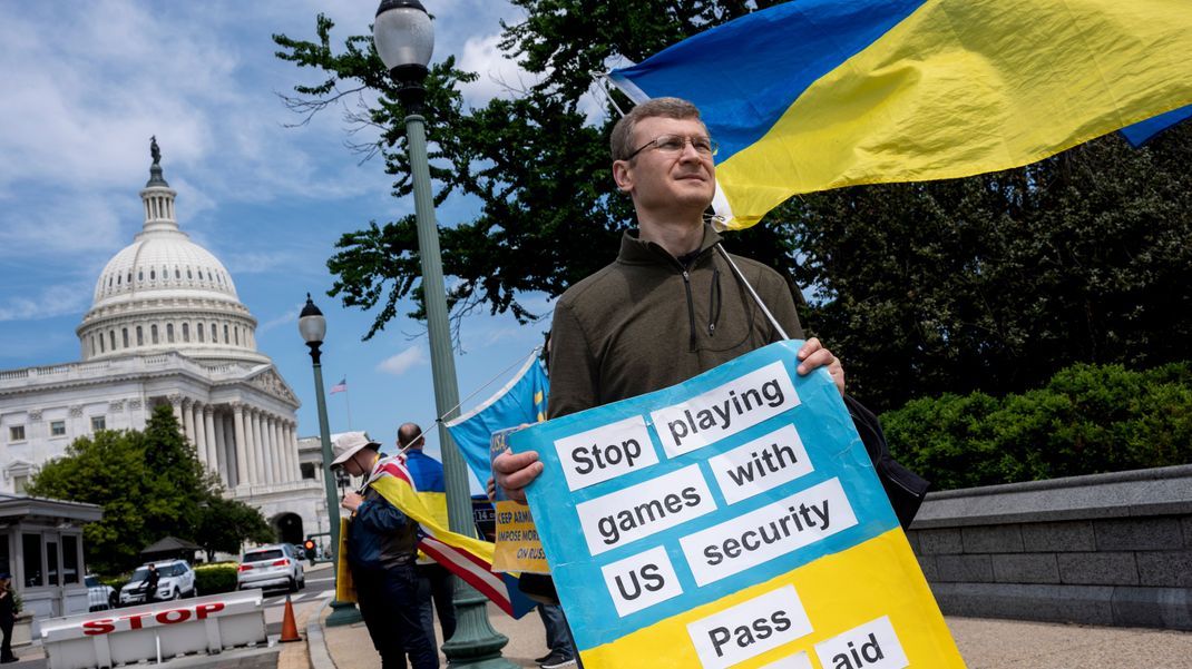 Aktivist:innen, die die Ukraine unterstützen, demonstrieren vor dem Kapitol, während sich das Repräsentantenhaus auf die Abstimmung über die Genehmigung von 95 Milliarden US-Dollar an Auslandshilfe für die Ukraine, Israel und andere Verbündete der USA vorbereitet.