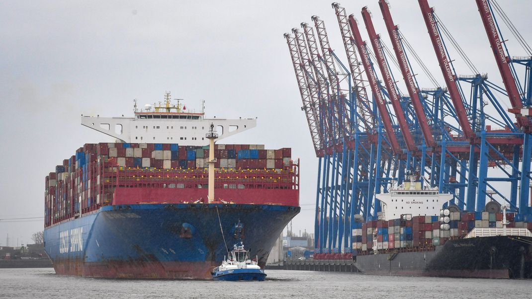 Ein Schlepper zieht bei widrigem Wetter ein Containerschiff aus dem Containerhafen in Hamburg hinaus auf die Elbe.