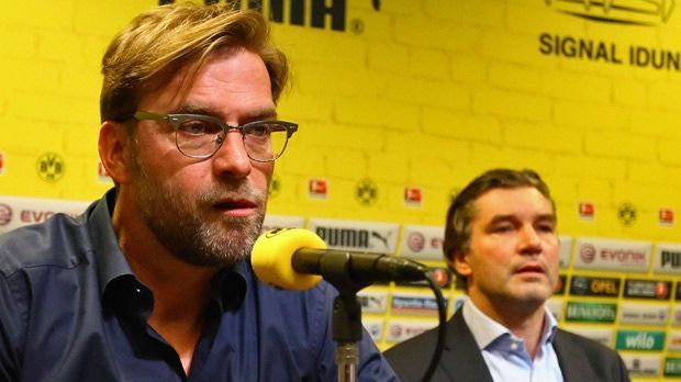 
                <strong>Abschieds-Pressekonferenz 2015</strong><br>
                Abschieds-Pressekonferenz 2015: Am 15. April wurde es offiziell. Klopp kündigte seinen Abschied zum Saisonende an. Trotz laufenden Vertrages vereinbarten Dortmund und Klopp eine Beendigung des Arbeitverhältnisses mit 30. Juni 2015. Zu diesem Zeitpunkt war der BVB sportlich schon wieder einigermaßen stabil. Nach der Hinrunde 2014/2015 war Klopps Team sogar noch auf einem Abstiegsplatz.
              