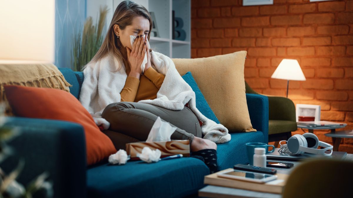 Woman with cold and flu blowing her nose