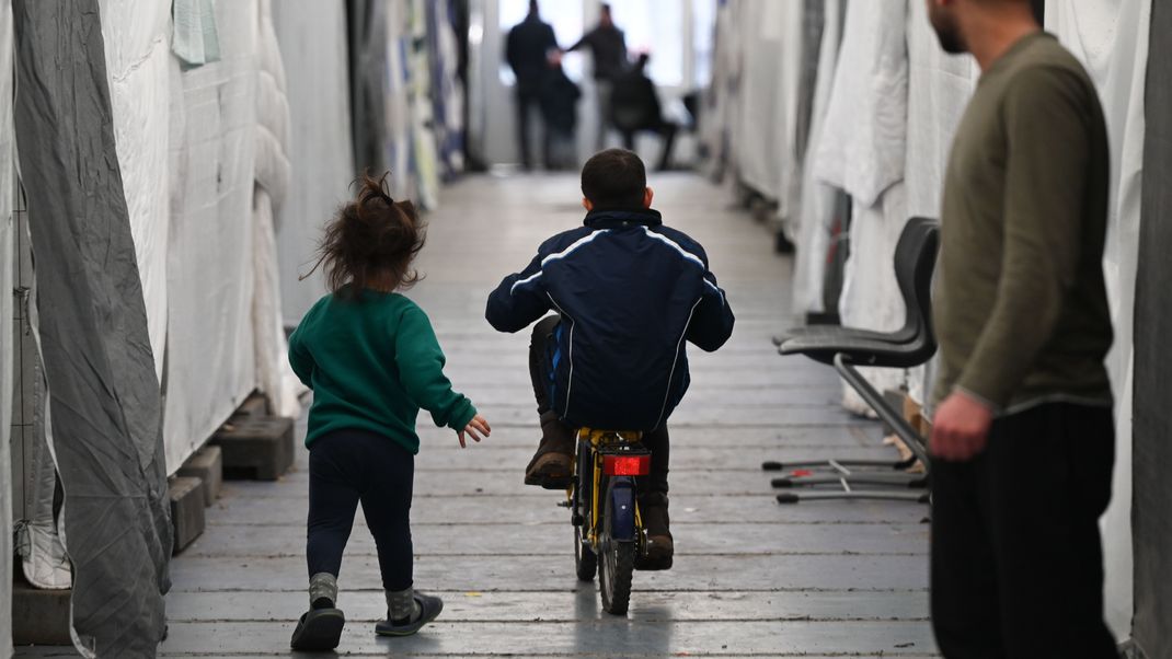 Hessen, Bensheim: Geflüchtete sind in einem der Zelte einer provisorischen Flüchtlingsunterkunft unterwegs.