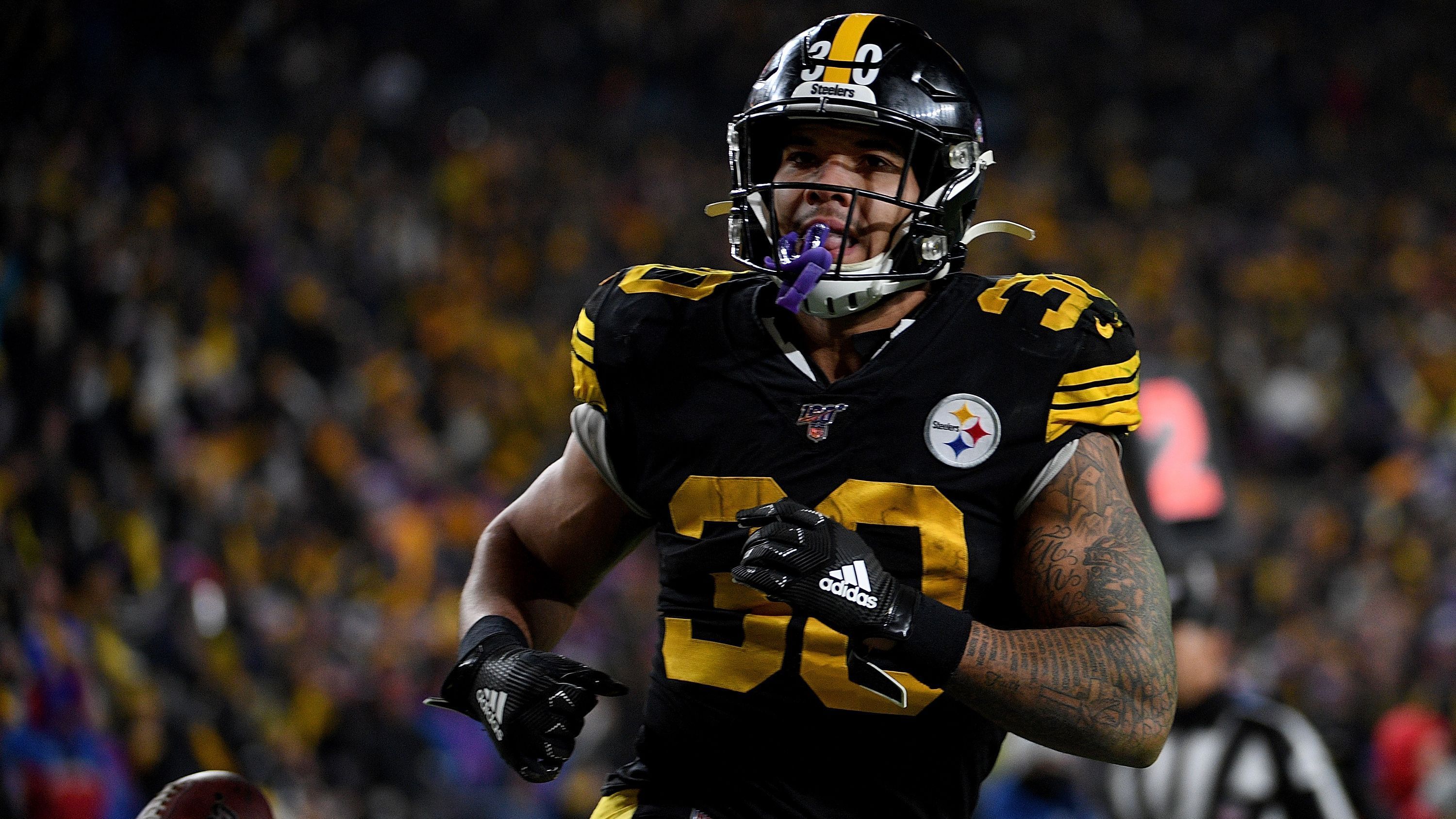 
                <strong>Pittsburgh Steelers</strong><br>
                Die Pittsburgh Steelers suchen nach dem Abgang des ehemaligen Stars Le'Veon Bell weiter nach einer dauerhaften Lösung. Nachdem James Conner während Bells Holdouts in der Saison 2018 nahtlos übernahm und mit 973 Rushing Yards, 12 Rushing Touchdowns und 497 Passing Yards in 15 Spielen in die Bresche sprang und zu überzeugen wusste, brachen Conners Zahlen in der vergangenen Saison ein. Wegen anhaltender Oberschenkelprobleme kam der 24-Jährige nur in 10 Spielen zum Einsatz und enttäuschte dabei mit 464 Rushing Yards, vier Rushing Touchdowns und lediglich 4,0 Yards pro Lauf (2018: 4,5 Yards/Game). Sein Vertrag läuft nach der kommenden Saison ebenfalls aus, wodurch die Steelers womöglich frühzeitig für Ersatz sorgen könnten, wenn sie Conner nicht den Turnaround zutrauen.
              