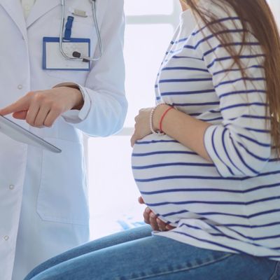 Beautiful smiling pregnant woman with the doctor at hospital