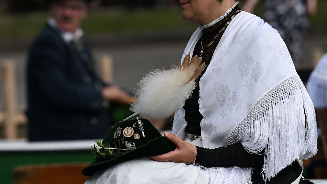 Frau in traditionellem Dirndl mit einem Trachtenhut.