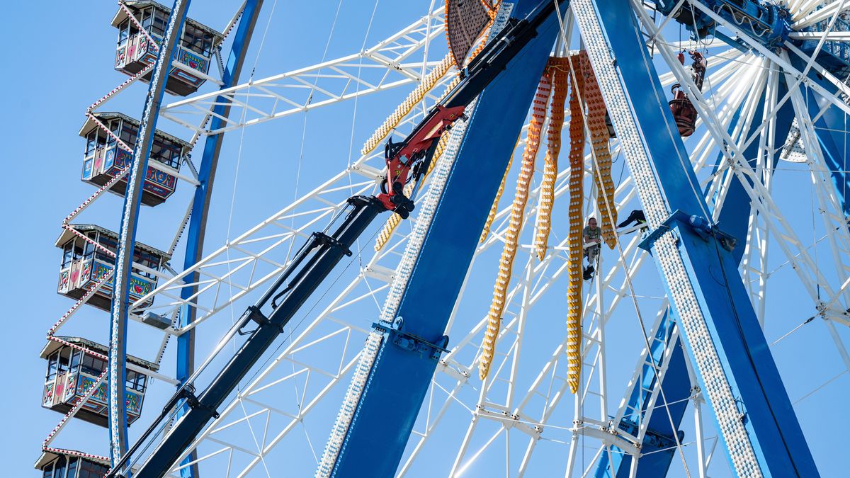 Männer arbeiten an dem Riesenrad auf dem Gelände des Gäubodenvolksfestes.