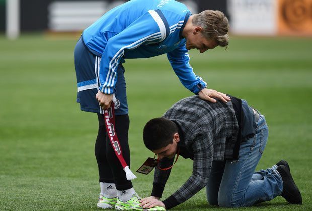 
                <strong>Georgischer Fan huldigt Bastian Schweinsteiger</strong><br>
                Ganz offensichtlich ist Schweinsteiger sein Lieblingsspieler, denn der junge Mann kniet sich vor dem neuen deutschen Kapitän hin und deutet an, ihm die Schuhe zu putzen.
              