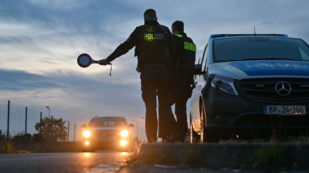 Beamte der Bundespolizei stoppen einen Pkw bei der Einreise. 