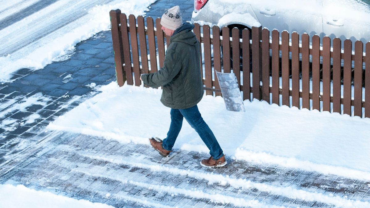 Mann räumt Schnee im Winter, Winterdienst, Wintereinbruch