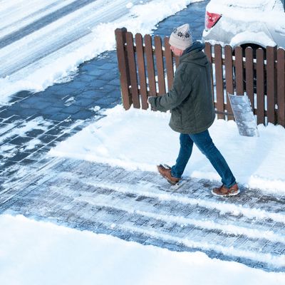 Mann räumt Schnee im Winter, Winterdienst, Wintereinbruch