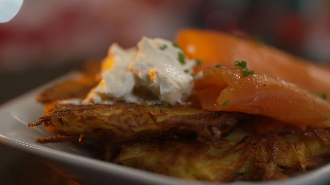 Als herzhaftes Mittagessen kannst du Kartoffelpuffer mit Creme Fraiche und Blattsalat servieren. Als Topping für den Puffer eignet sich auch Räucherlachs. 