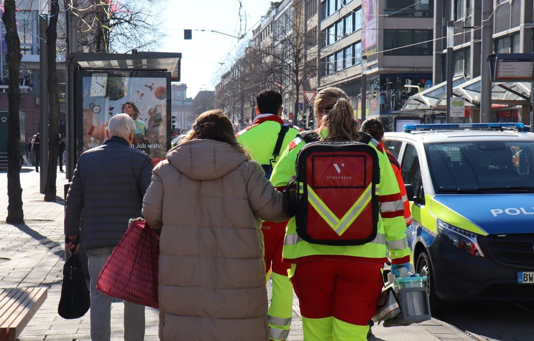 Rettungskräfte begleiten Menschen bei einem Großeinsatz der Polizei in der Innenstadt. 