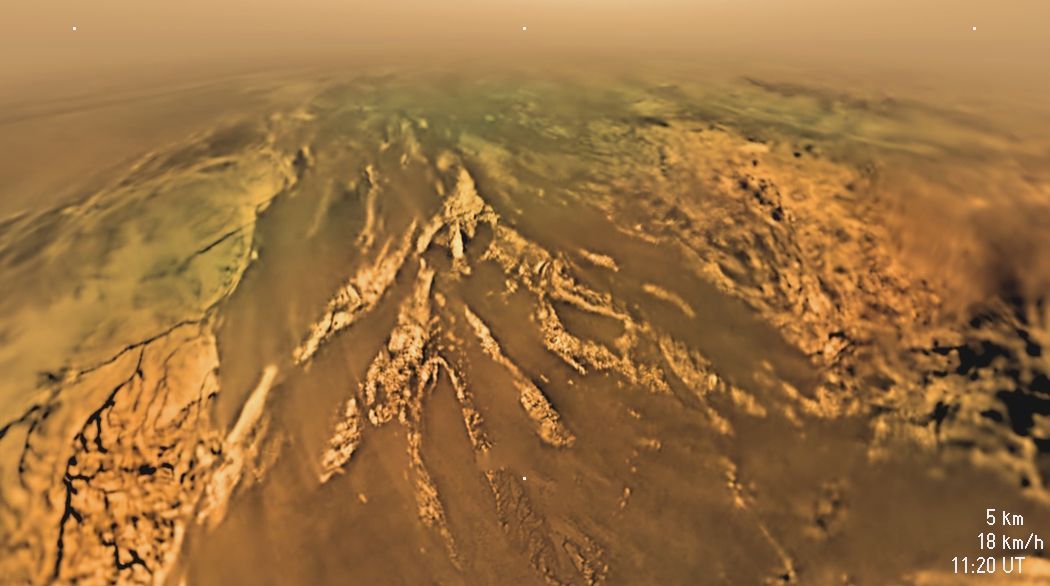 Landeanflug auf Titan: Aus 5 Kilometer Höhe blickt die Landesonde Huygens auf Berge und Täler des -180 Grad kalten Saturnmondes. Da seine Atmosphäre aus Stickstoff und Methan dichter als die der Erde ist, konnte die Sonde mit einem Fallschirm landen.