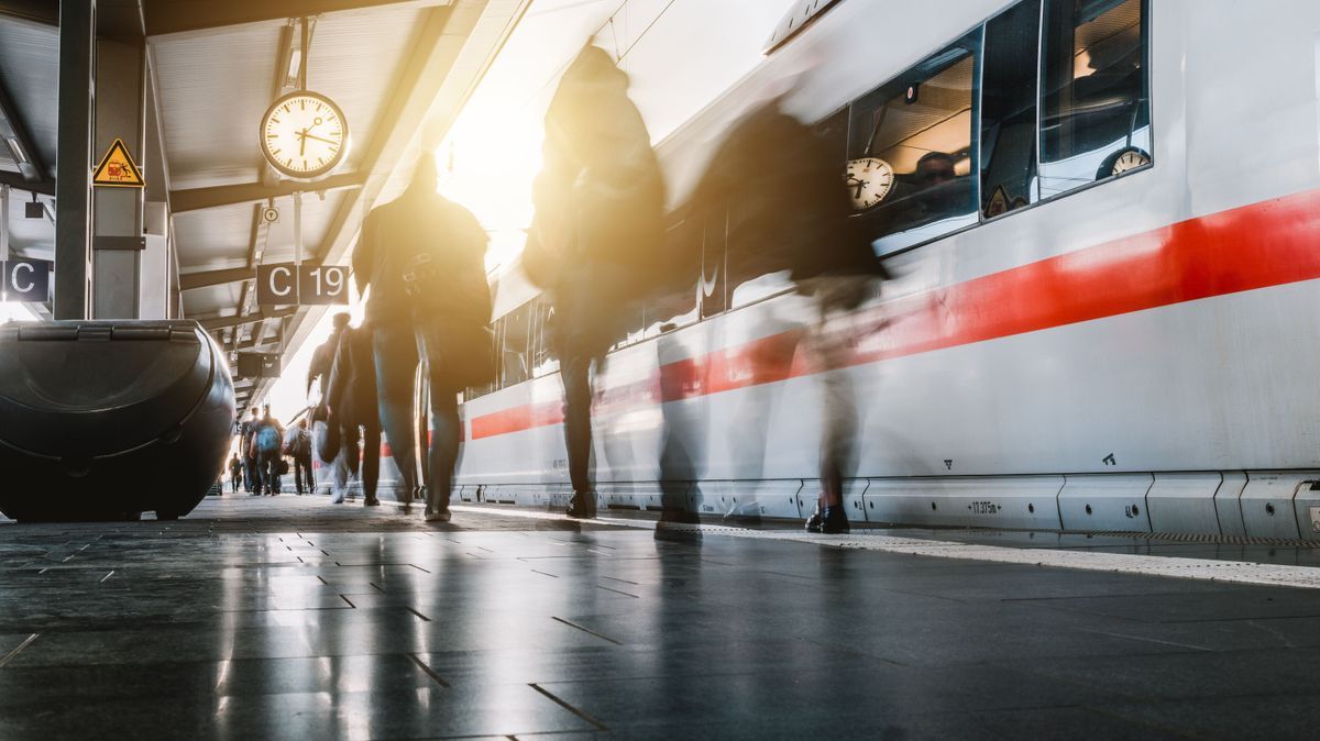 Menschen gehen auf dem Bahnsteig 