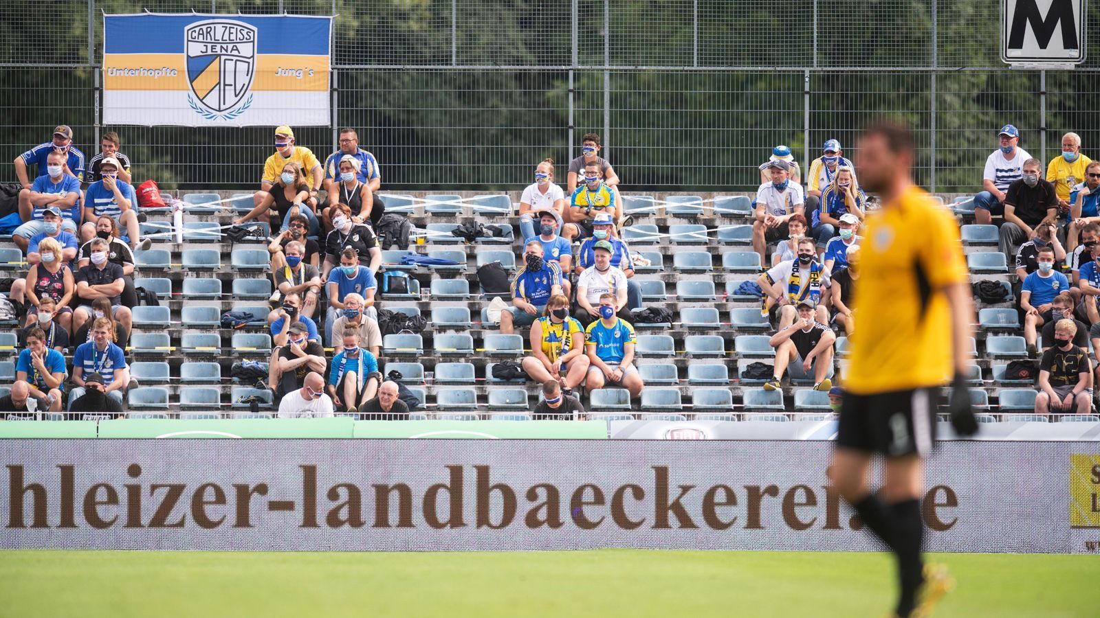 
                <strong>Carl Zeiss Jena - SV Babelsberg (Thüringen)</strong><br>
                Bei Jenas Heimspiel gegen Babelsberg (1:1) waren 1.895 Zuschauer erlaubt. Damit entsprach die Stadt Jena einem zuvor vom Verein vorgelegten Konzept. Das Spiel wird im Nachhinein zur Auswertung genutzt, um damit eine Grundlage für die Genehmigung von Zuschauern bei kommenden Spielen von Carl Zeiss zu haben. Gegen Babelsberg wurde das Kontingent von 1.895 Zuschauern voll ausgeschöpft. Schon an den Eingängen sollte durch gezielten Ordner-Einsatz eine Staubildung verhindert werden. Teil des Konzepts war das verpflichtende Tragen von Mund-Nasen-Schutzes durch die Zuschauer.
              