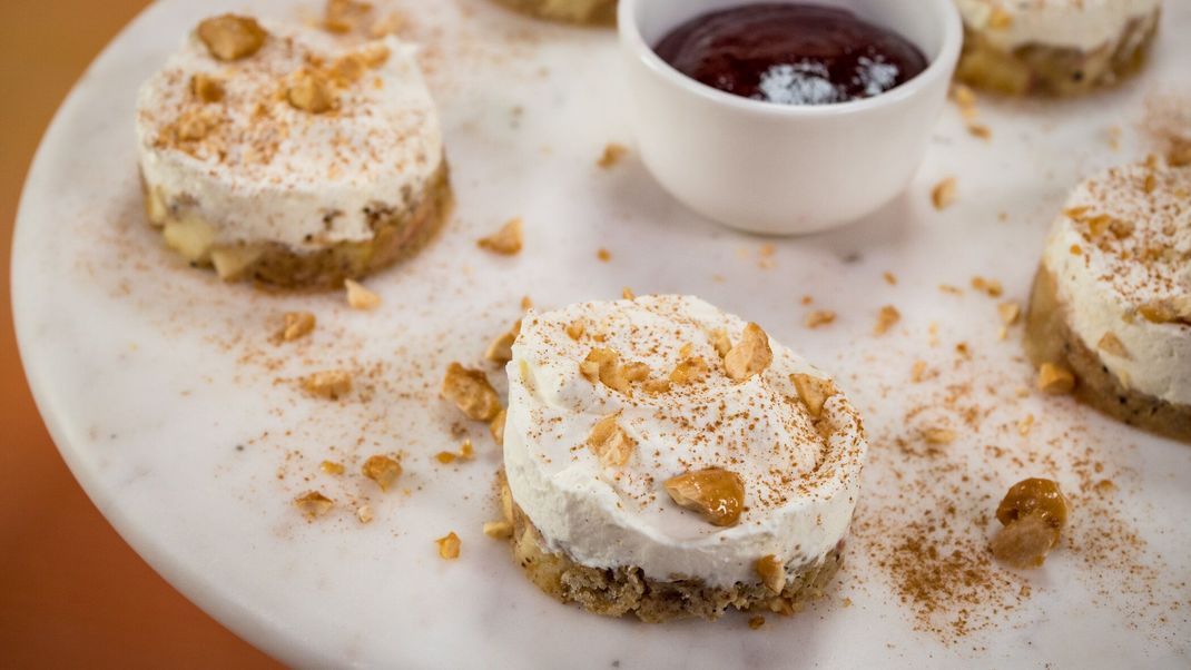 Apple-Crumble-Törtchen mit Vanille-Mascarpone-Sahne-Creme, Kirschsoße und gebrannten Mandeln