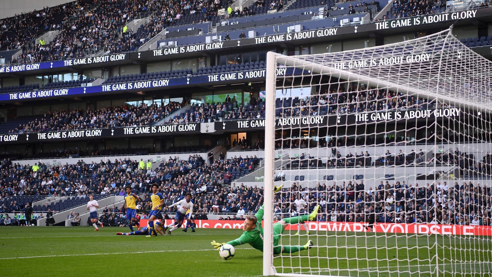 
                <strong>Erster Torschütze ist J'Neil Bennett</strong><br>
                J'Neil Bennett von den Tottenham-Junioren ist mit einem schönen Schlenzer ins Eck erster Torschütze im neuen Stadion. In diesem Bild gut zu sehen sind die digitalen Displays an den Rängen, auf denen Werbung oder Statistiken während der Spiele angezeigt werden können.
              