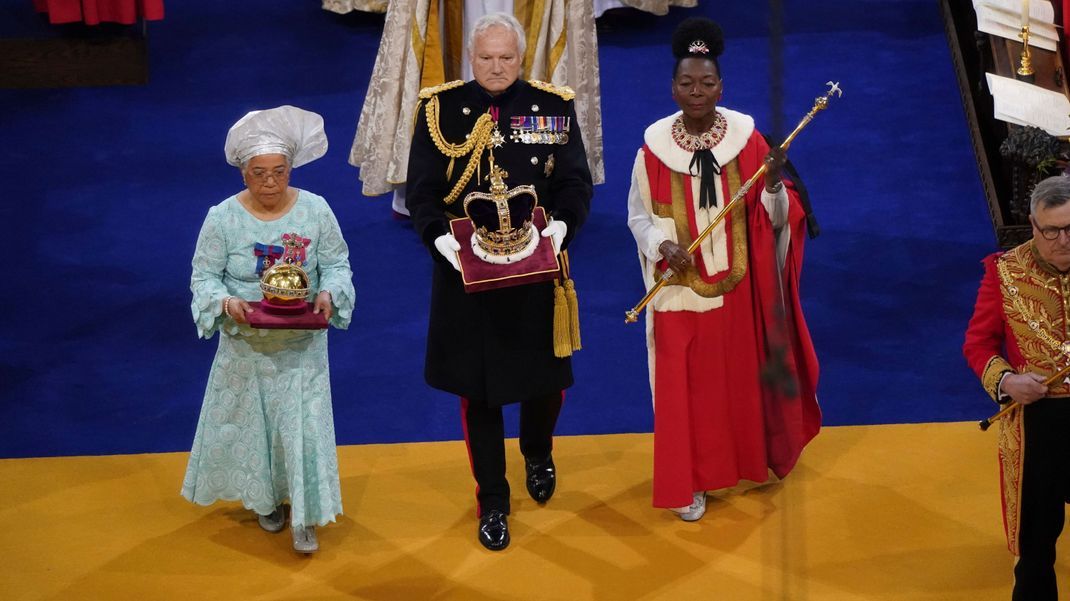 König Charles III. bekommt die drei Insignien überreicht.