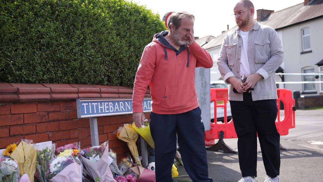 30. Juli 2024, Großbritannien, Southport: Menschen trauern neben Blumen in der Nähe des Tatorts in der Hart Street, wo am Montag während eines Taylor-Swift-Events in einer Tanzschule bei einem Messerangriff mehrere Kinder starben und weitere verletzt wurden.