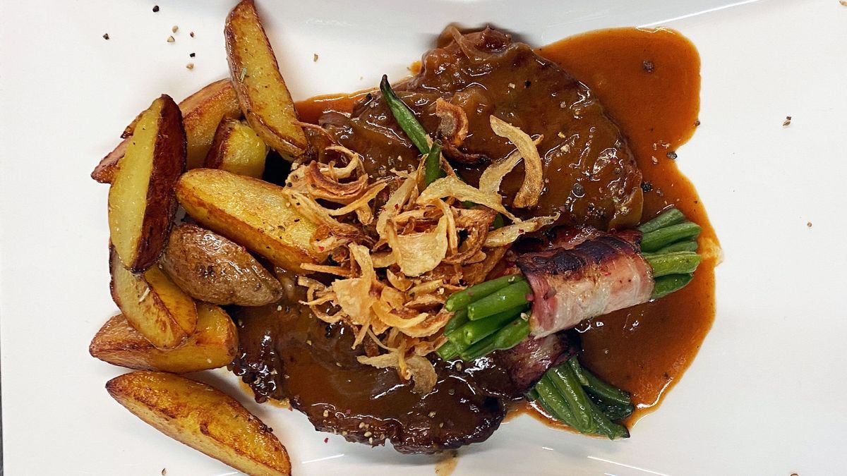 Klassischer Zwiebelrostbraten mit gebratenen Kartoffeln, Speckbohnenbündchen und gerösteter Zwiebel