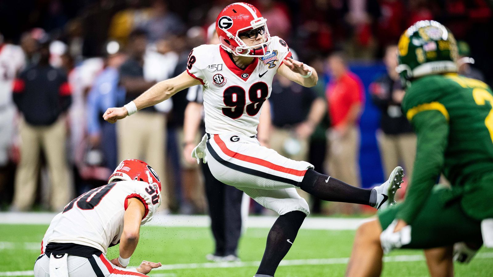 
                <strong>Rodrigo Blankenship (Kicker, Georgia)</strong><br>
                Der Kicker mit der Brille und dem Mega-Schuss: Blankenship dürfte im Draft 2020 nahezu sicher als erster Kicker gepickt werden. Der Akteur von Georgia hat ein starkes Schussbein und verwandelte am College sechs von neun Tritten über 50 Yards. Field Goals unter 40 Yards traf er zu 92,7 Prozent. Kleiner Wermutstropfen: Ausgerechnet in der letzten Saison verschoss er sechs Field Goals. Das dürfte an seinem hohen Ansehen indes nur wenig ändern. 2019 gewann er den Lou Groza Award - eine Auszeichnung für Kicker. Blankenship ist auch ein guter Kickoff-Schütze und schießt auffällig viele Touchbacks. Falls es mit dem Football entgegen der Erwartungen doch nicht klappt, könnte der 23-Jährige sein Glück in der Musikbranche versuchen: Im April 2018 veröffentlichte er einen Rap-Song.
              