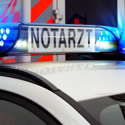 Teilansicht Feuerwehreinsatzfahrzeug mit Blaulicht und Notarztfahrzeug. Notruf 112