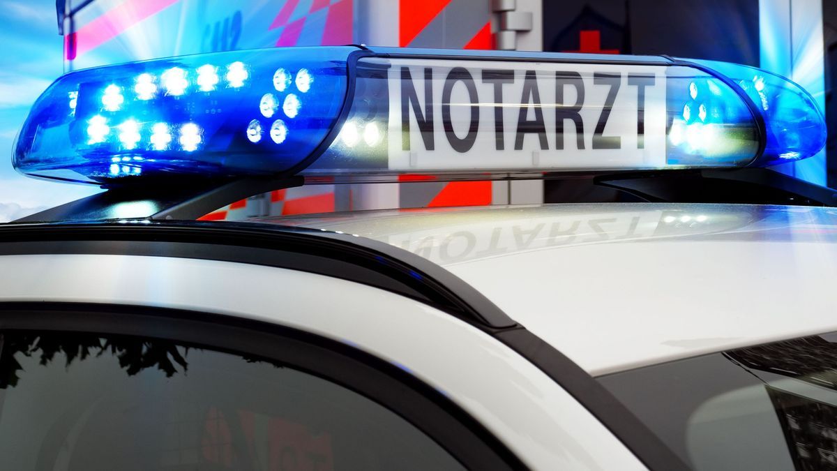 Teilansicht Feuerwehreinsatzfahrzeug mit Blaulicht und Notarztfahrzeug. Notruf 112