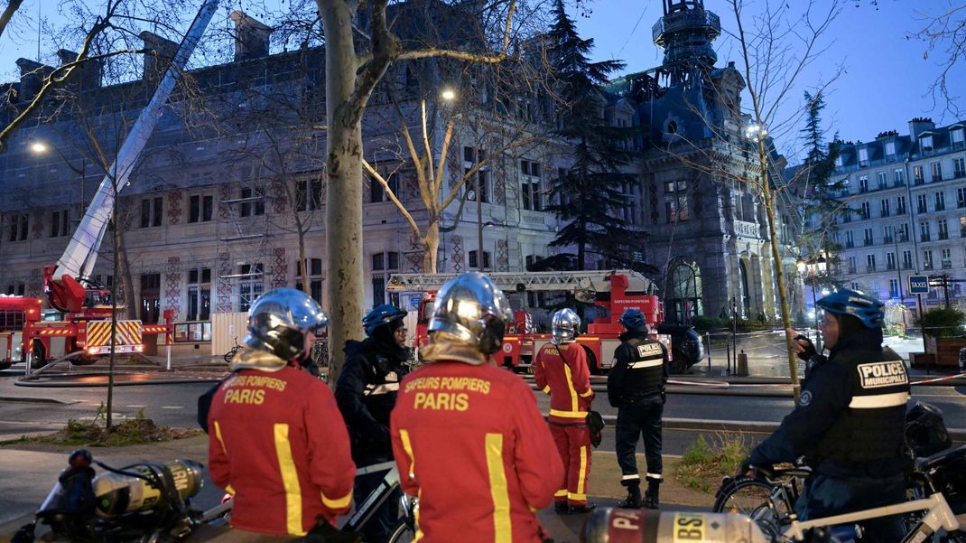 Feuerwehrleute und Polizisten arbeiten am Rathaus des 12. Arrondissement von Paris, nachdem es von einem spektakulären Feuer heimgesucht wurde.