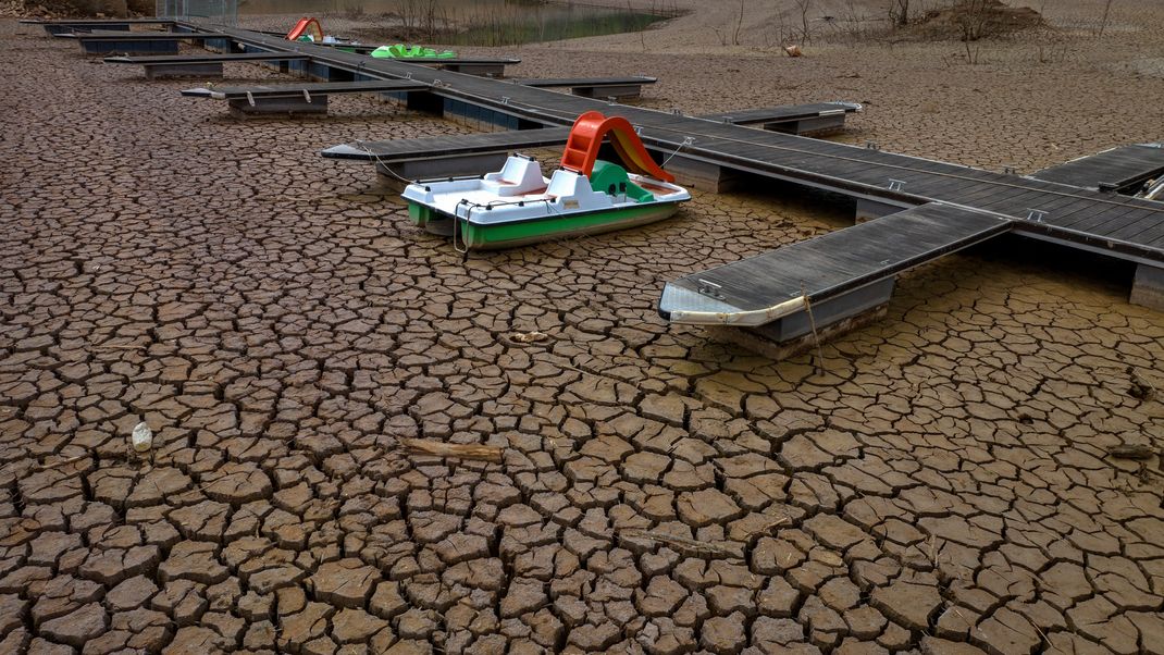 Ein Tretboot ist an einem Steg in einem ausgetrockneten Teil des Sau-Stausees, etwa 100 km nördlich von Barcelona, festgemacht. 