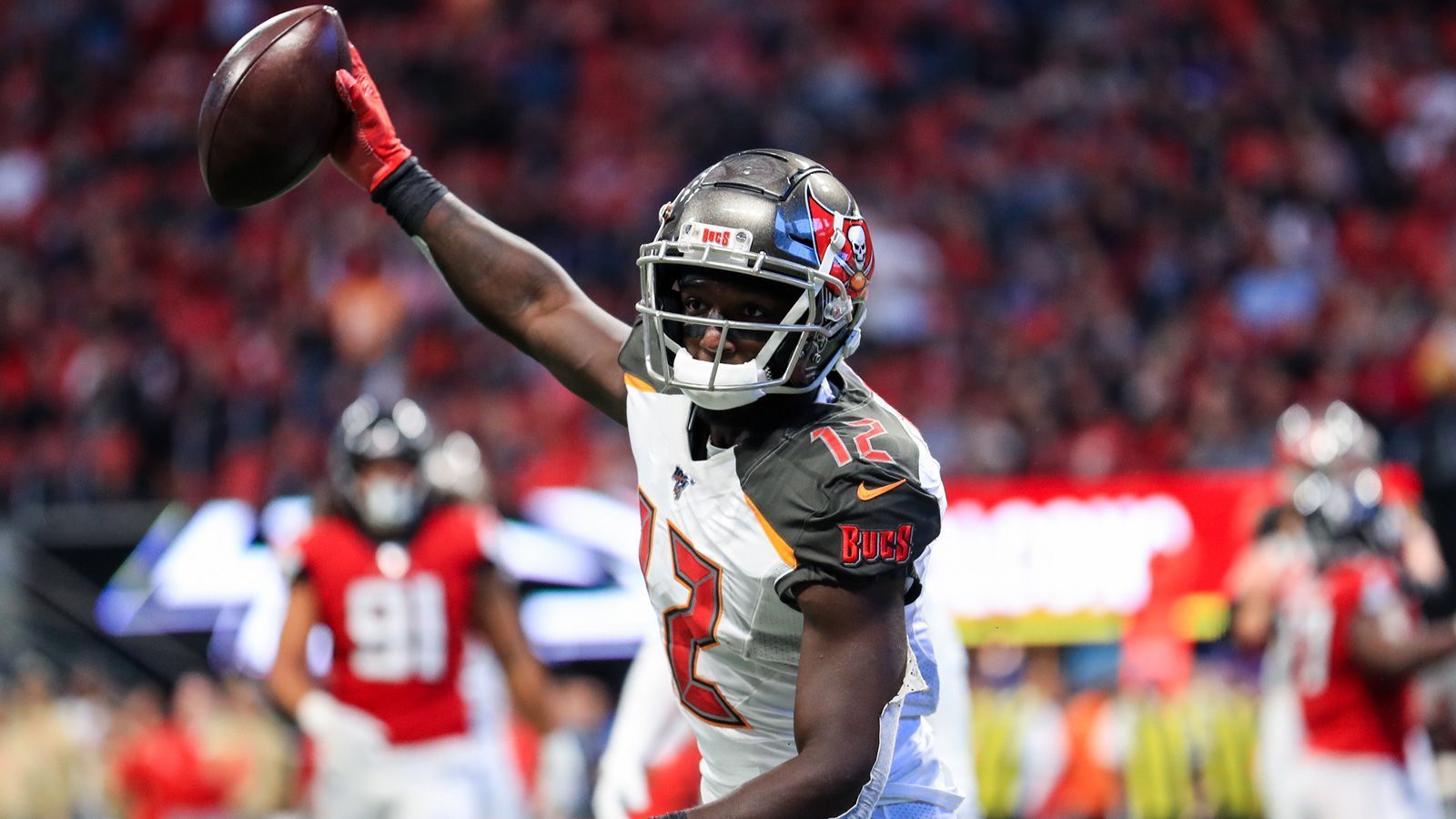 
                <strong>Chris Godwin (Tampa Bay Buccaneers)</strong><br>
                Das eine Trikotnummer wochenlang Thema sein kann, hat jeder NFL-Fan nach dem Wechsel von Tom Brady zu den Tampa Bay Buccaneers mitbekommen. Letztlich gab Chris Godwin nach und hat seine Nummer Brady kostenlos überlassen. Daher trägt der Wide Receiver zukünftig die Nummer , statt der .
              