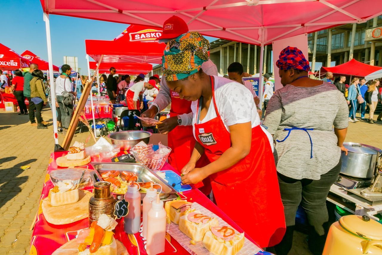 Auf einem Straßenfest im Soweto werden verschiedene Brotgerichte zubereitet.