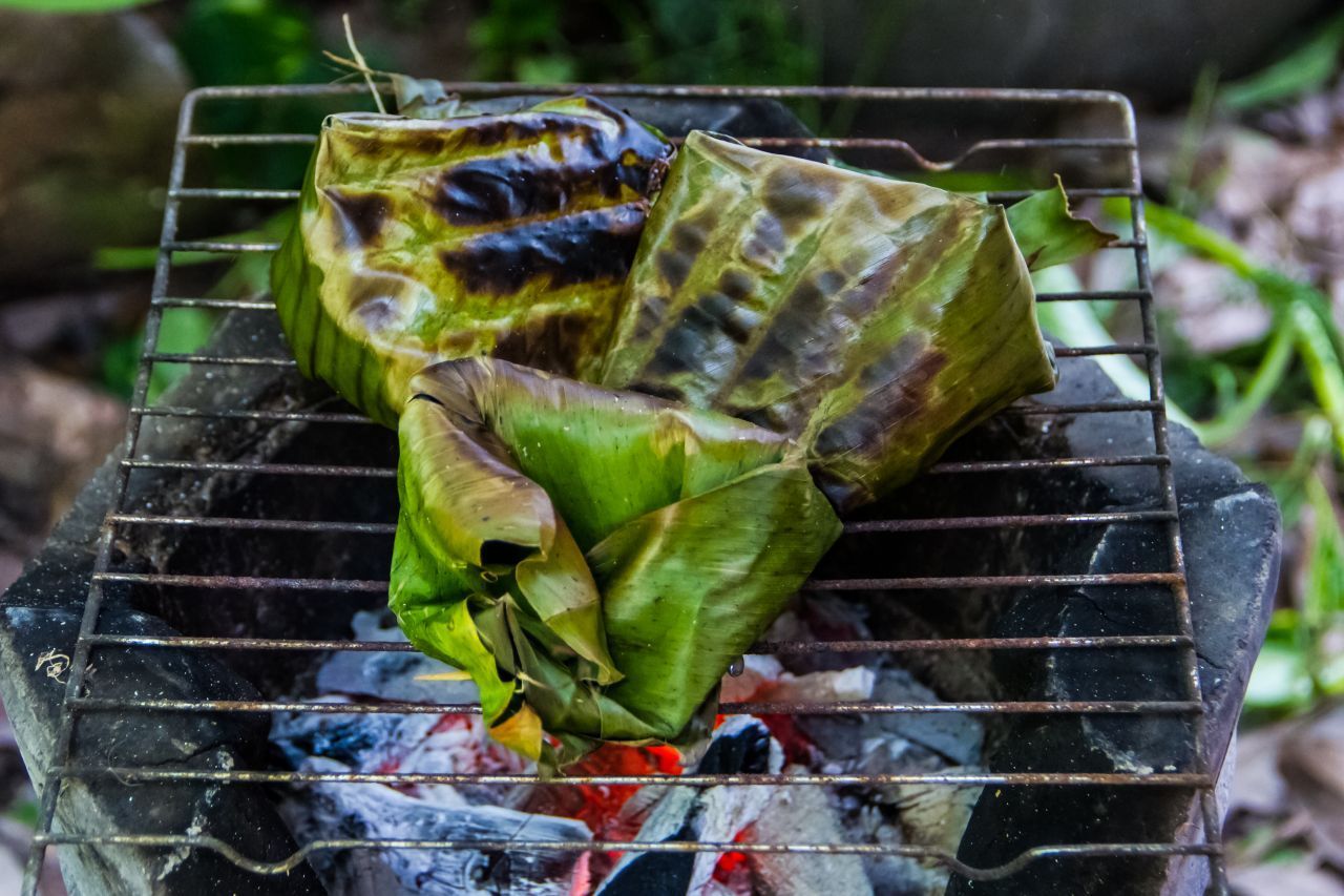 Eine exotische Variante als Grill-Hülle: Bananenblätter. Funktioniert aber auch mit großen Kohlblättern. Mit kleinen Holzspießen steckst du das Ganze fest.