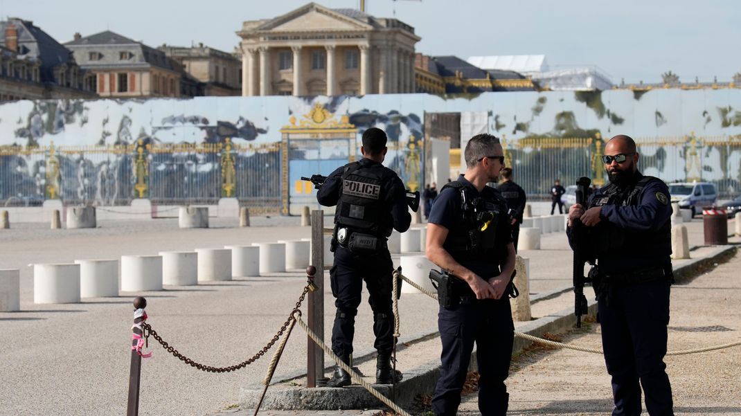 Französische Polizisten bewachen den Eingang des Schlosses von Versailles bei Paris nach einem Sicherheitsalarm. Das Schloss von Versailles und sein Park sind am 20. Oktober 2023 wegen einer erneuten Bombendrohung geräumt worden.
