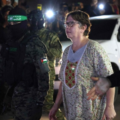 Hamas and Islamic Jihad fighters accompany a newly released hostage before handing them over to the Red Cross in Rafah, in the southern Gaza Strip on November 28, 2023. 