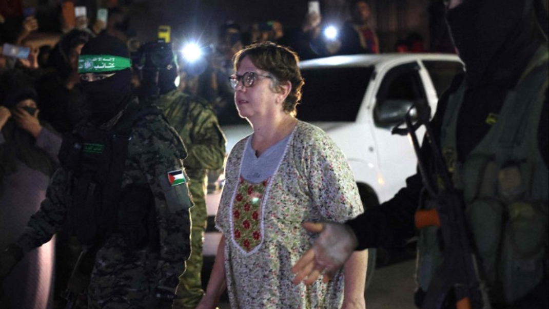 Hamas and Islamic Jihad fighters accompany a newly released hostage before handing them over to the Red Cross in Rafah, in the southern Gaza Strip on November 28, 2023. 